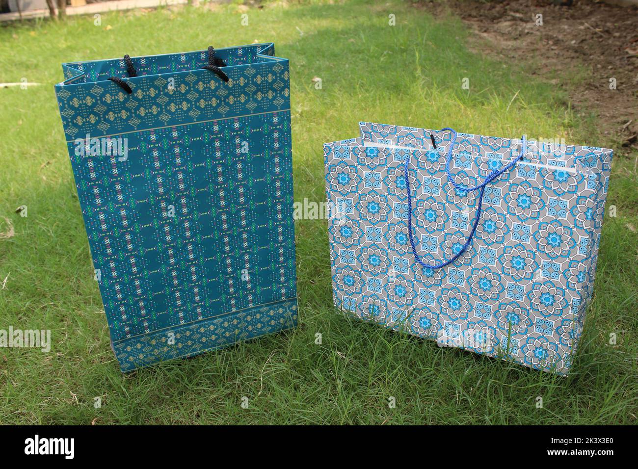 Bunte Papier Einkaufstaschen sind isoliert auf einem grünen natürlichen Hintergrund. Keine Plastiktüten nur umweltfreundliche Taschen. Stockfoto