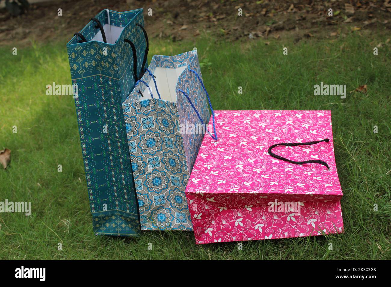 Bunte Papier Einkaufstaschen sind isoliert auf einem grünen natürlichen Hintergrund. Keine Plastiktüten nur umweltfreundliche Taschen. Stockfoto