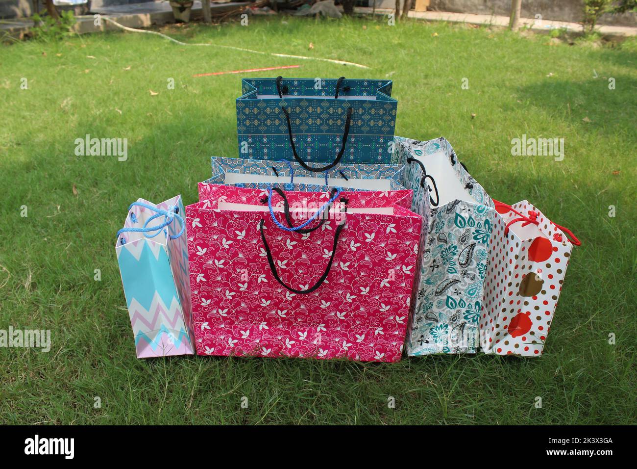 Bunte Papier Einkaufstaschen sind isoliert auf einem grünen natürlichen Hintergrund. Keine Plastiktüten nur umweltfreundliche Taschen. Stockfoto
