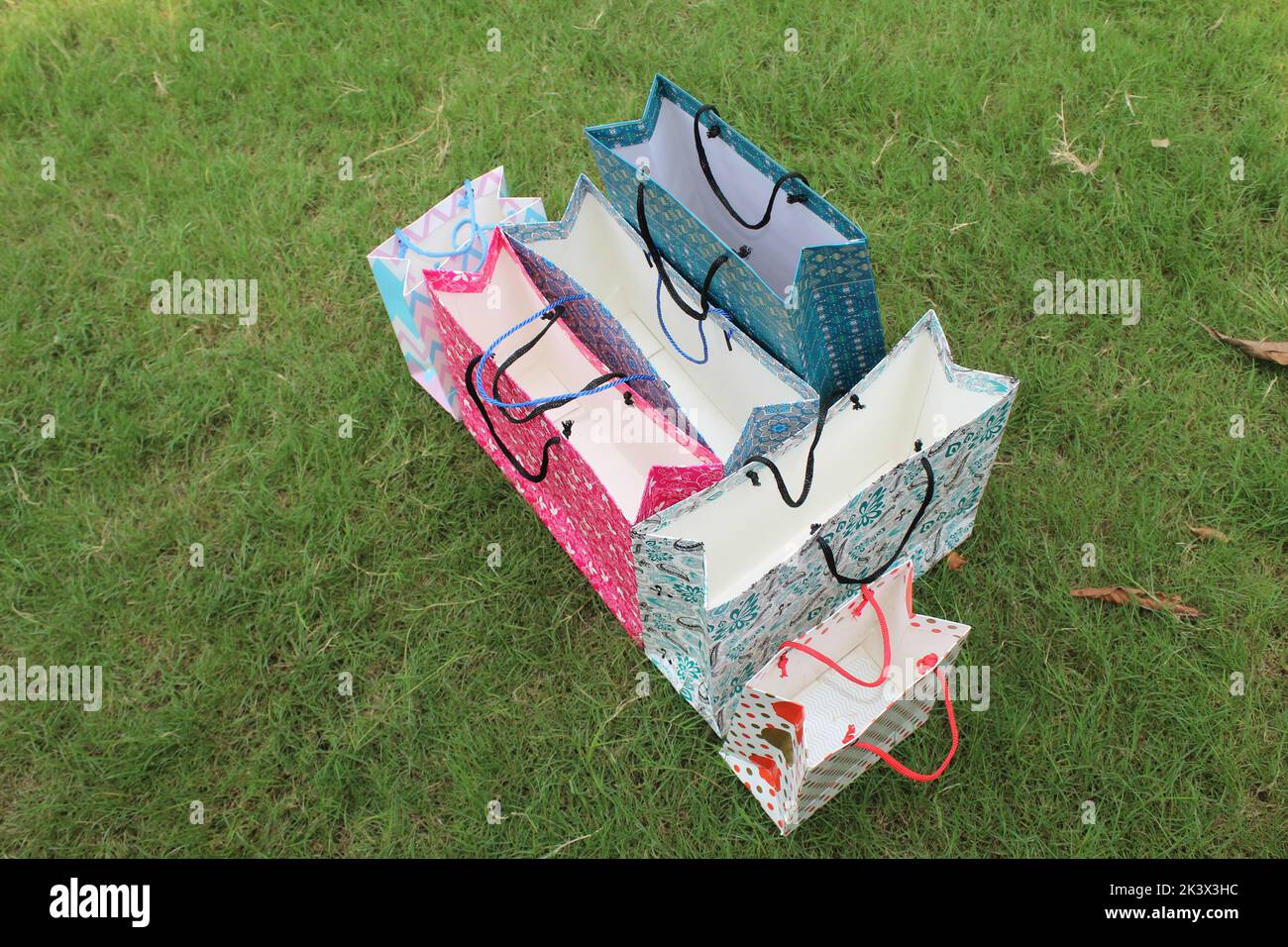 Bunte Papier Einkaufstaschen sind isoliert auf einem grünen natürlichen Hintergrund. Keine Plastiktüten nur umweltfreundliche Taschen. Stockfoto