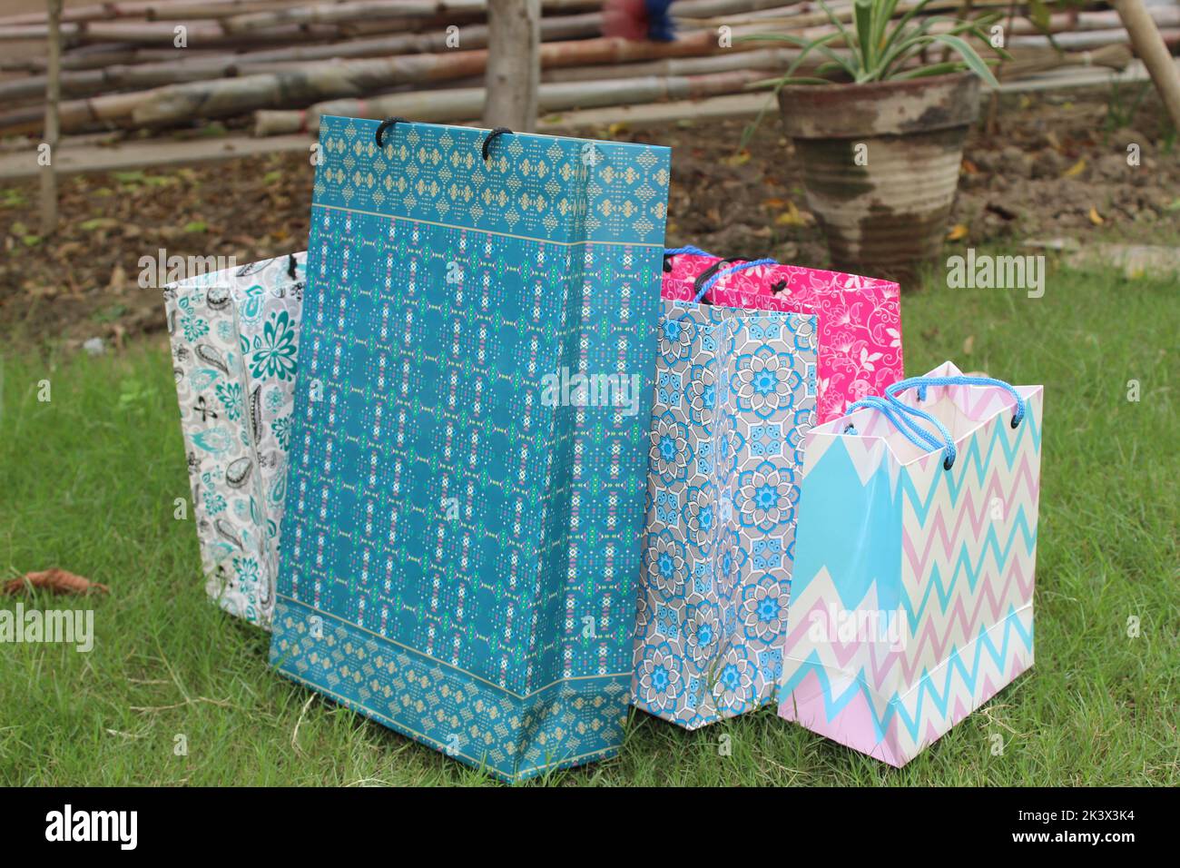 Bunte Papier Einkaufstaschen sind isoliert auf einem grünen natürlichen Hintergrund. Keine Plastiktüten nur umweltfreundliche Taschen. Stockfoto