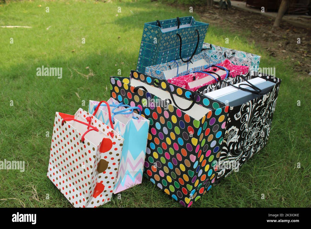 Bunte Papier Einkaufstaschen sind isoliert auf einem grünen natürlichen Hintergrund. Keine Plastiktüten nur umweltfreundliche Taschen. Stockfoto