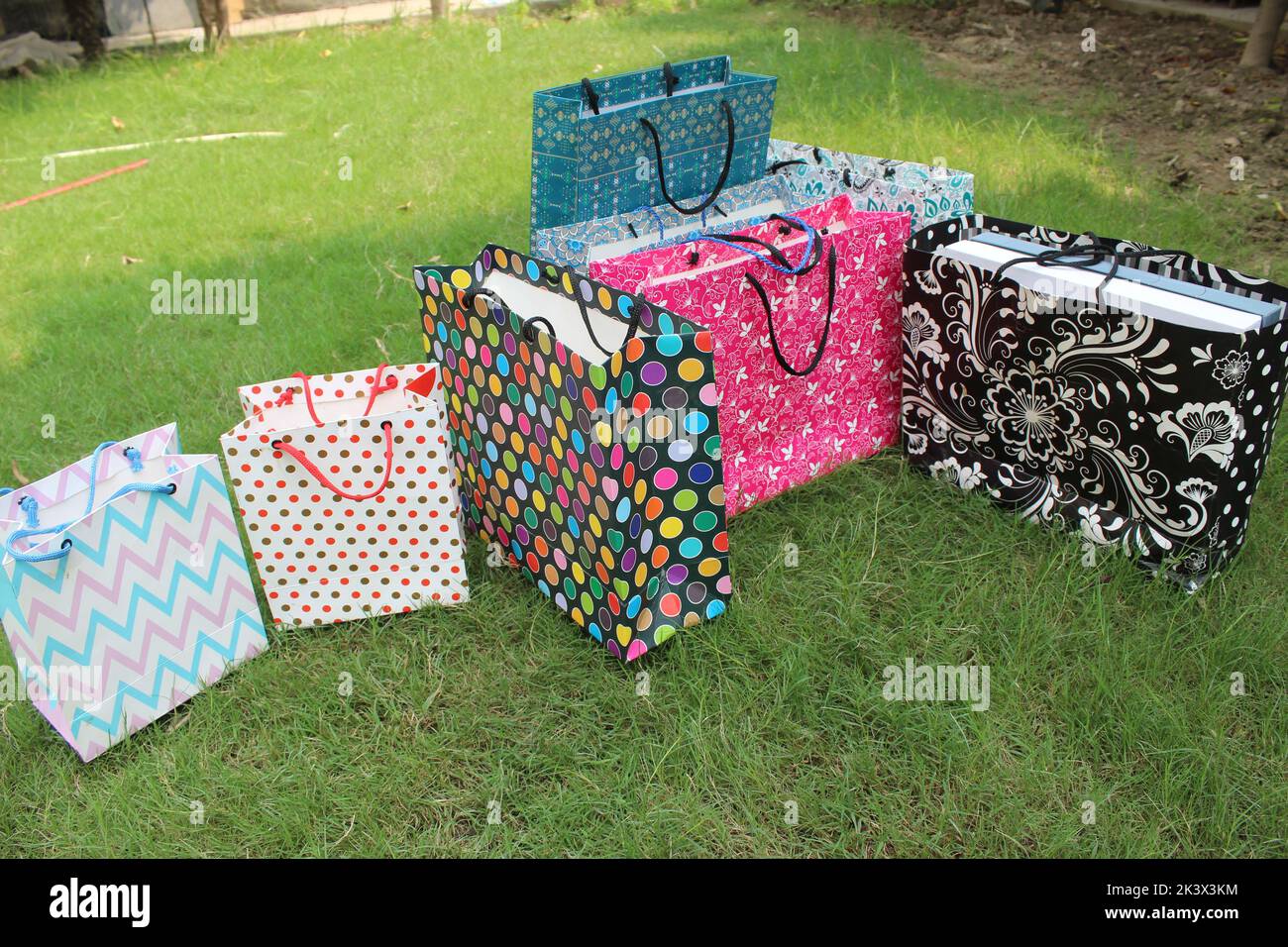 Bunte Papier Einkaufstaschen sind isoliert auf einem grünen natürlichen Hintergrund. Keine Plastiktüten nur umweltfreundliche Taschen. Stockfoto