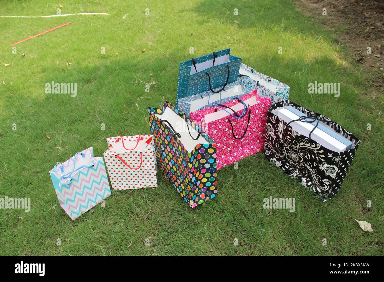 Bunte Papier Einkaufstaschen sind isoliert auf einem grünen natürlichen Hintergrund. Keine Plastiktüten nur umweltfreundliche Taschen. Stockfoto