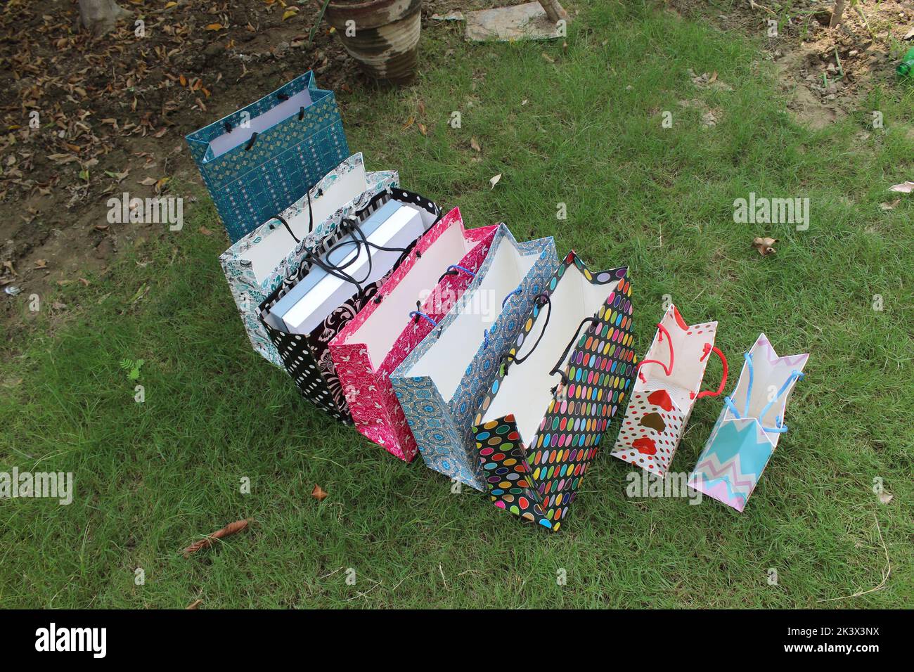 Bunte Papier Einkaufstaschen sind isoliert auf einem grünen natürlichen Hintergrund. Keine Plastiktüten nur umweltfreundliche Taschen. Stockfoto