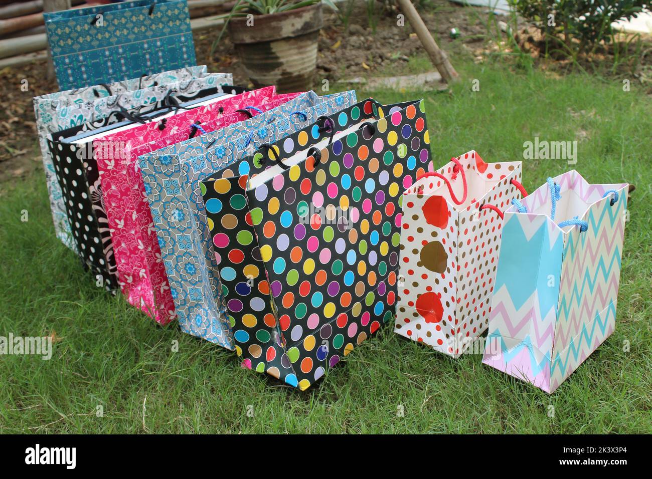 Bunte Papier Einkaufstaschen sind isoliert auf einem grünen natürlichen Hintergrund. Keine Plastiktüten nur umweltfreundliche Taschen. Stockfoto