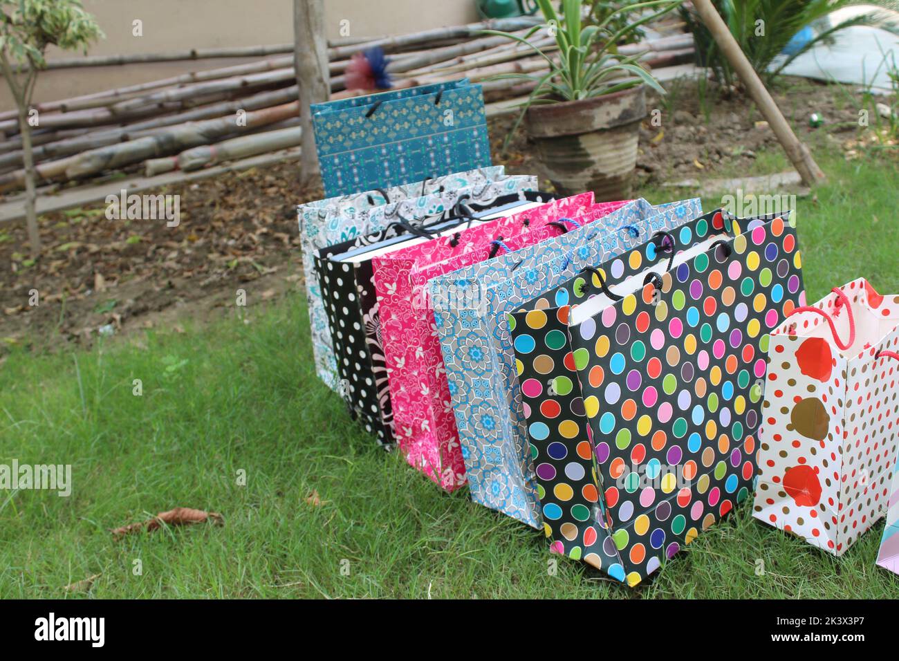 Bunte Papier Einkaufstaschen sind isoliert auf einem grünen natürlichen Hintergrund. Keine Plastiktüten nur umweltfreundliche Taschen. Stockfoto