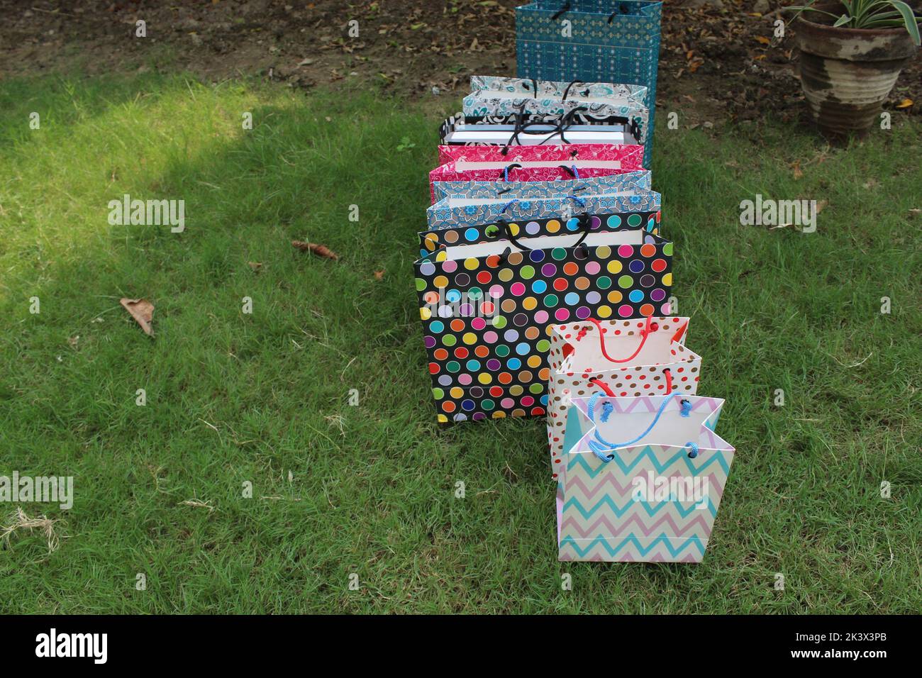 Bunte Papier Einkaufstaschen sind isoliert auf einem grünen natürlichen Hintergrund. Keine Plastiktüten nur umweltfreundliche Taschen. Stockfoto