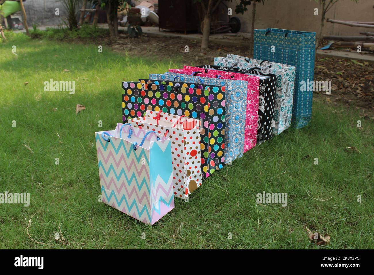 Bunte Papier Einkaufstaschen sind isoliert auf einem grünen natürlichen Hintergrund. Keine Plastiktüten nur umweltfreundliche Taschen. Stockfoto