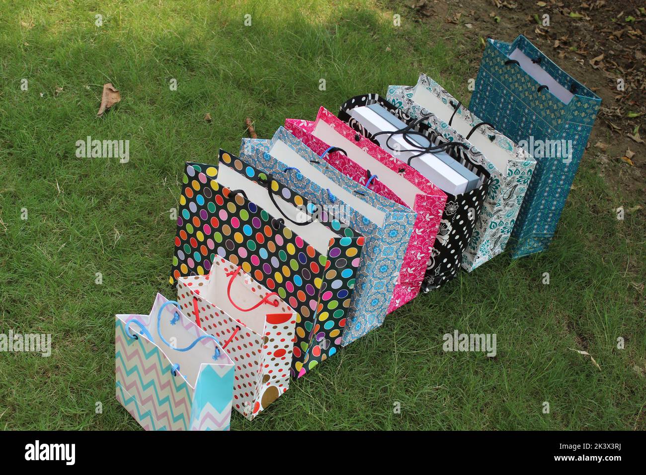 Bunte Papier Einkaufstaschen sind isoliert auf einem grünen natürlichen Hintergrund. Keine Plastiktüten nur umweltfreundliche Taschen. Stockfoto