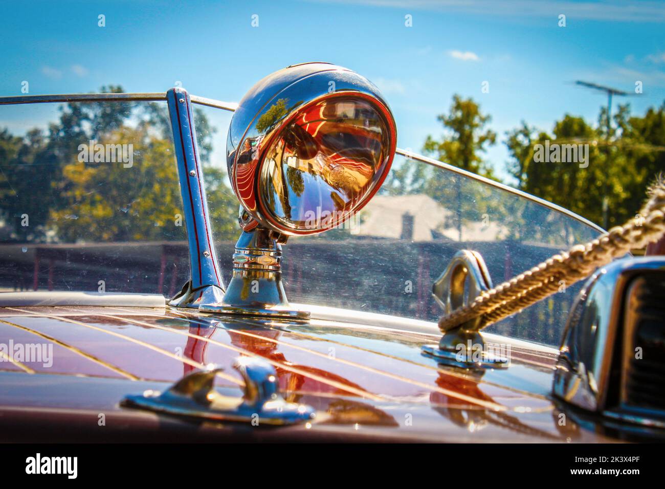 Spotlight auf Teakholz Rennboot mit Reflexionen von Holz und Umgebung auf Glas und Metall Stockfoto