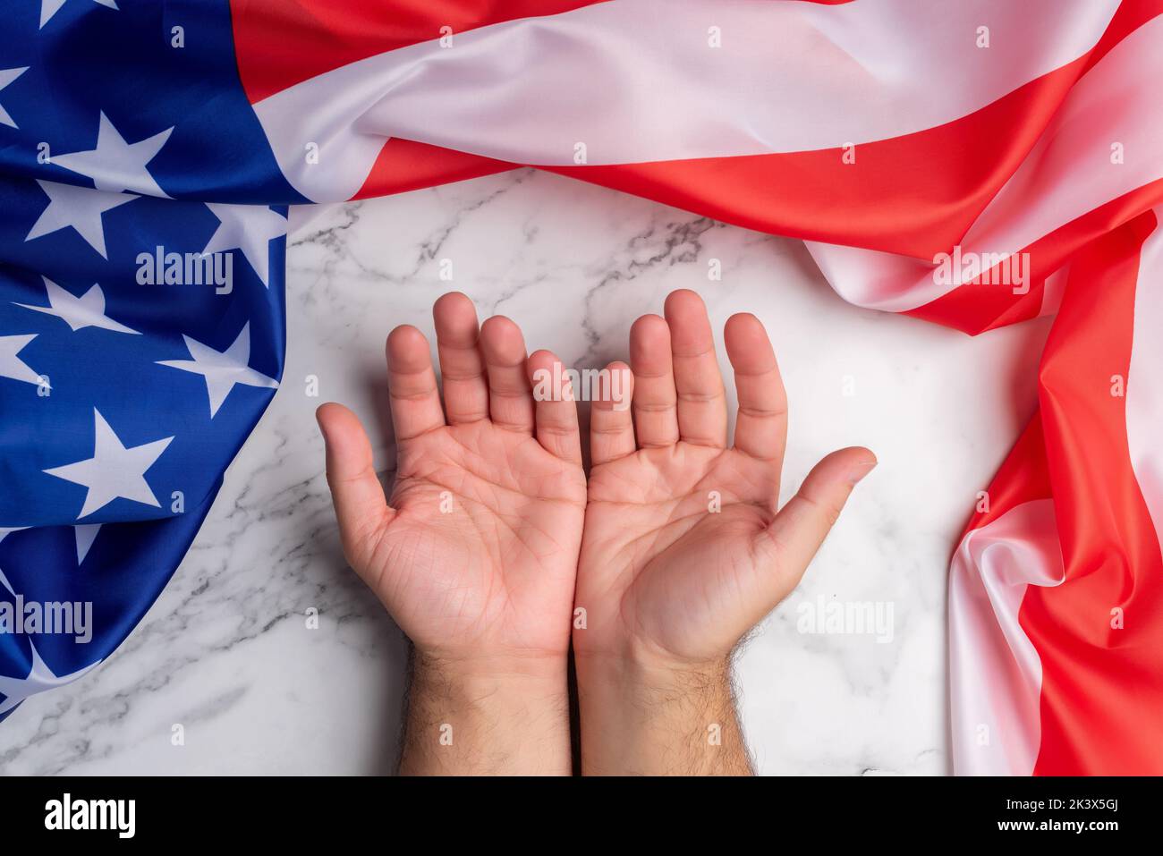 Hintergrund mit zwei offenen Händen, umgeben von der Flagge der Vereinigten Staaten von Amerika, die den Empfang und die gute Aufnahme dieses Landes symbolisiert. Kostenlos Stockfoto