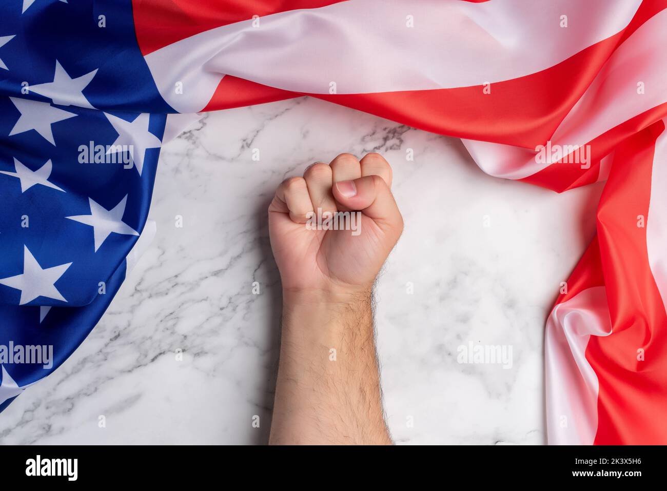 Hintergrund mit einer geballten Faust, umgeben von der Flagge der Vereinigten Staaten von Amerika. Amerikanischer Stolz und Macht. Kampf und Stärke für die Amerikaner Stockfoto