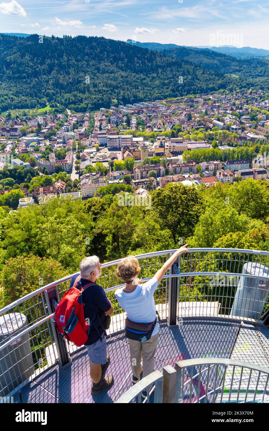 Mann und Frau genießen die Aussicht von der Spitze des Aussichtsturms Schlossberg in Schlossberg, Freiburg im Breisgau, Deutschland Stockfoto