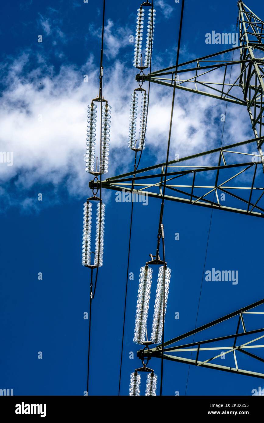 Isolatoren aus Glas an einer Hochspannungsleitung, an den Polen hängen sie als Aufhängevorrichtung zwischen dem Mast und dem stromführenden, nicht isolierten Kabel, ext Stockfoto