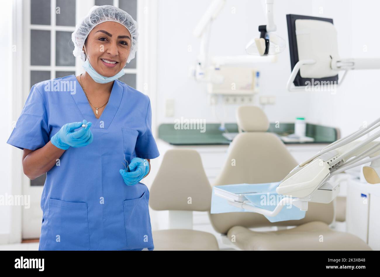 Lächelnde professionelle Zahnärztin Frau posiert in der Zahnklinik Stockfoto
