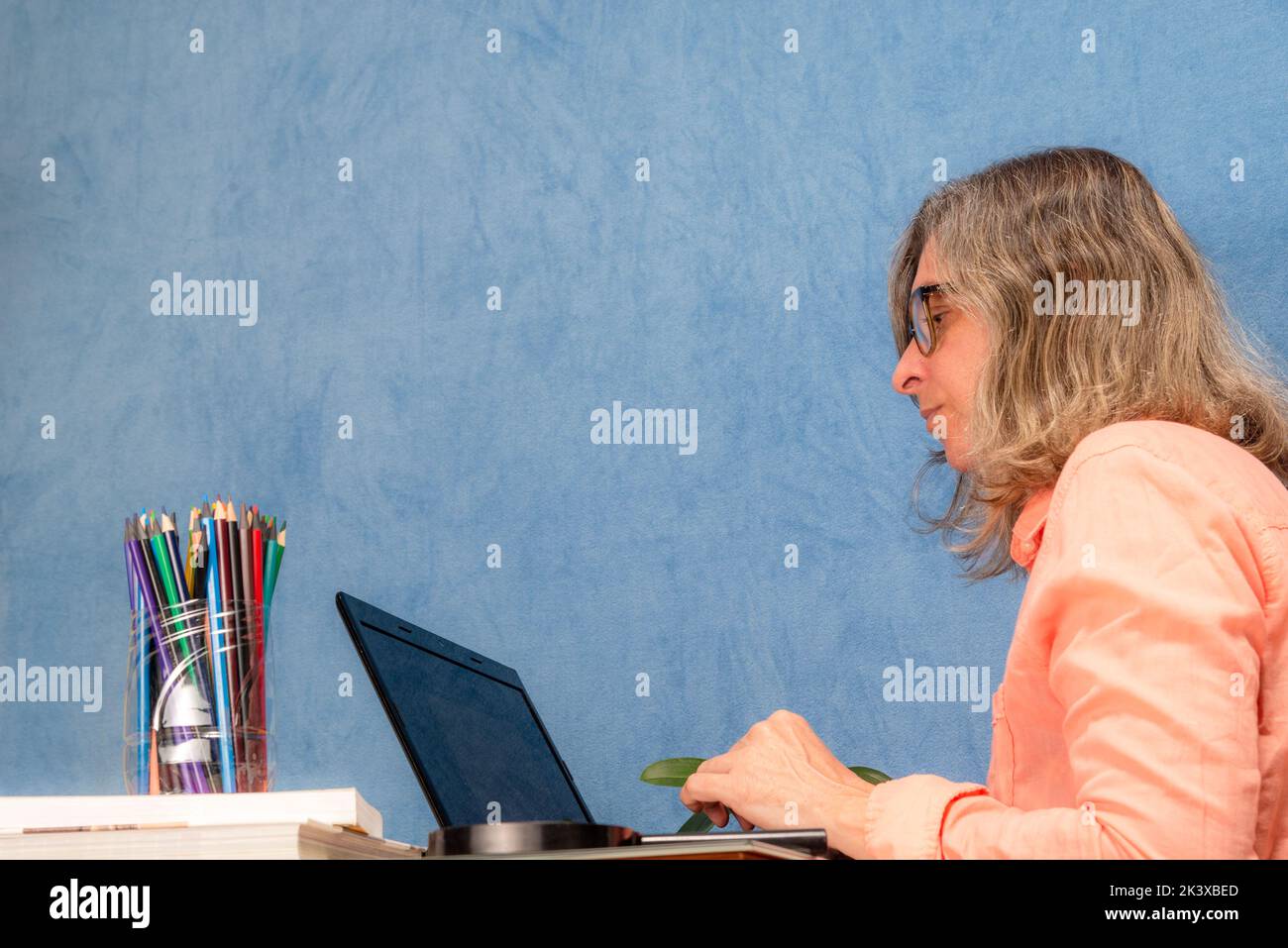 Seitwärts Frau mit Laptop-Computer zu Hause oder im Büro arbeiten. Business-, Menschen- und Technologiekonzept. Stockfoto