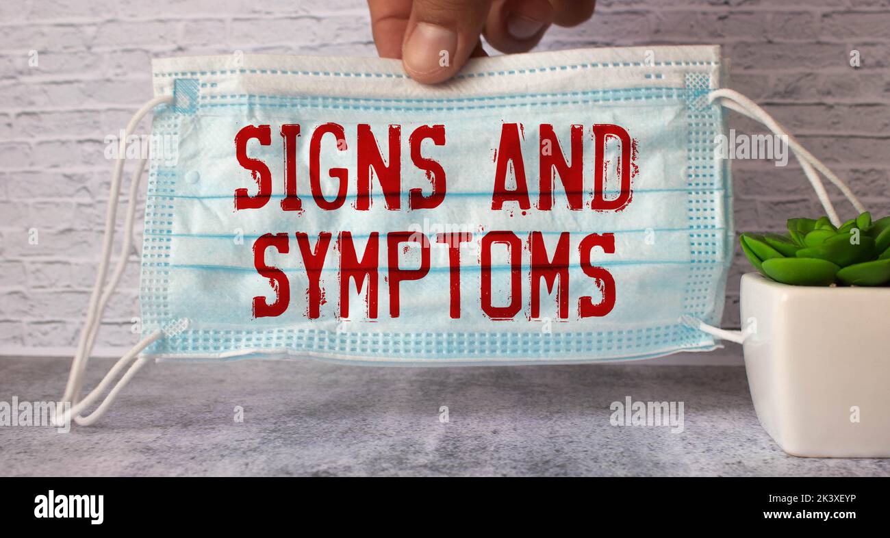 Auf blauem Hintergrund ein Stethoskop, ein Thermometer, Pillen, Medikamentenflaschen und ein Stück Papier mit den darin liegenden Zeichen UND SYMPTOMEN. Blick von der Stockfoto