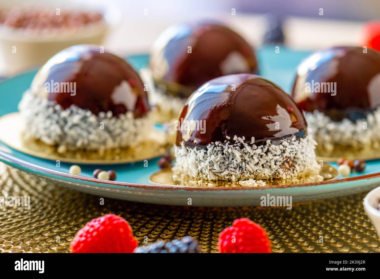 cupcake mit Schokoladencreme. Schokoladen-Rundkuchen mit Himbeere auf einem blauen Teller.Beerendessert. Luftiger Kuchen Souffle.appetitliche Cupcakes und Stockfoto