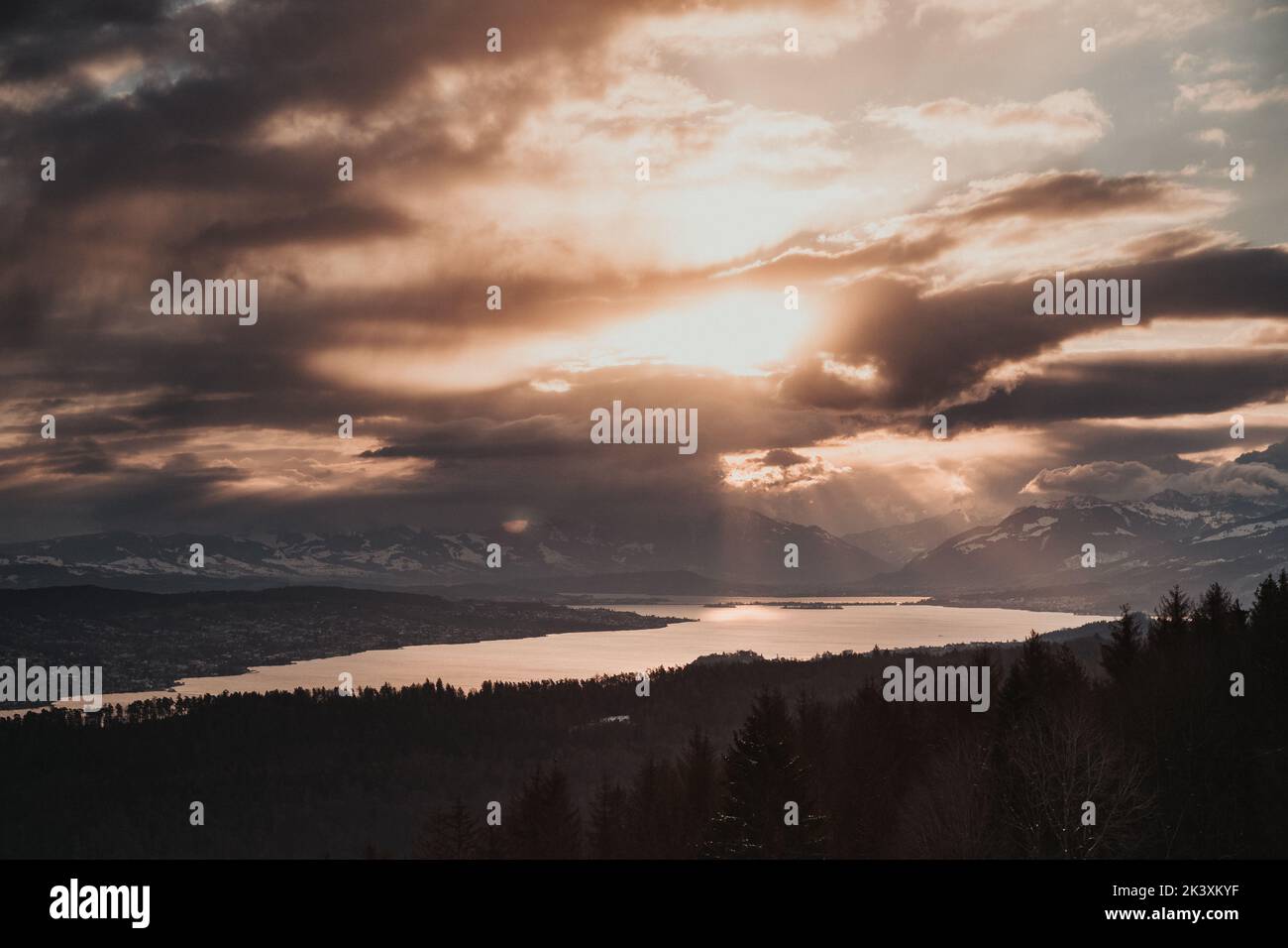 Fesselnde Farben des Sonnenuntergangs über dem ruhigen See, eine atemberaubende Harmonie der Farben der Natur. Stockfoto