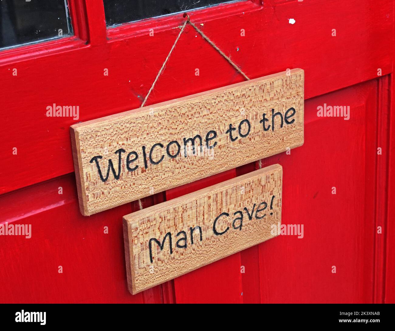 Willkommen beim "man Cave" -Schild an einer roten Tür Stockfoto