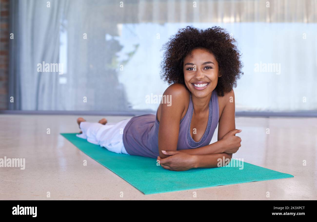 Was für ein tolles Workout. Ganzkörperportrait einer attraktiven jungen Frau, die auf einer Übungsmatte liegt. Stockfoto