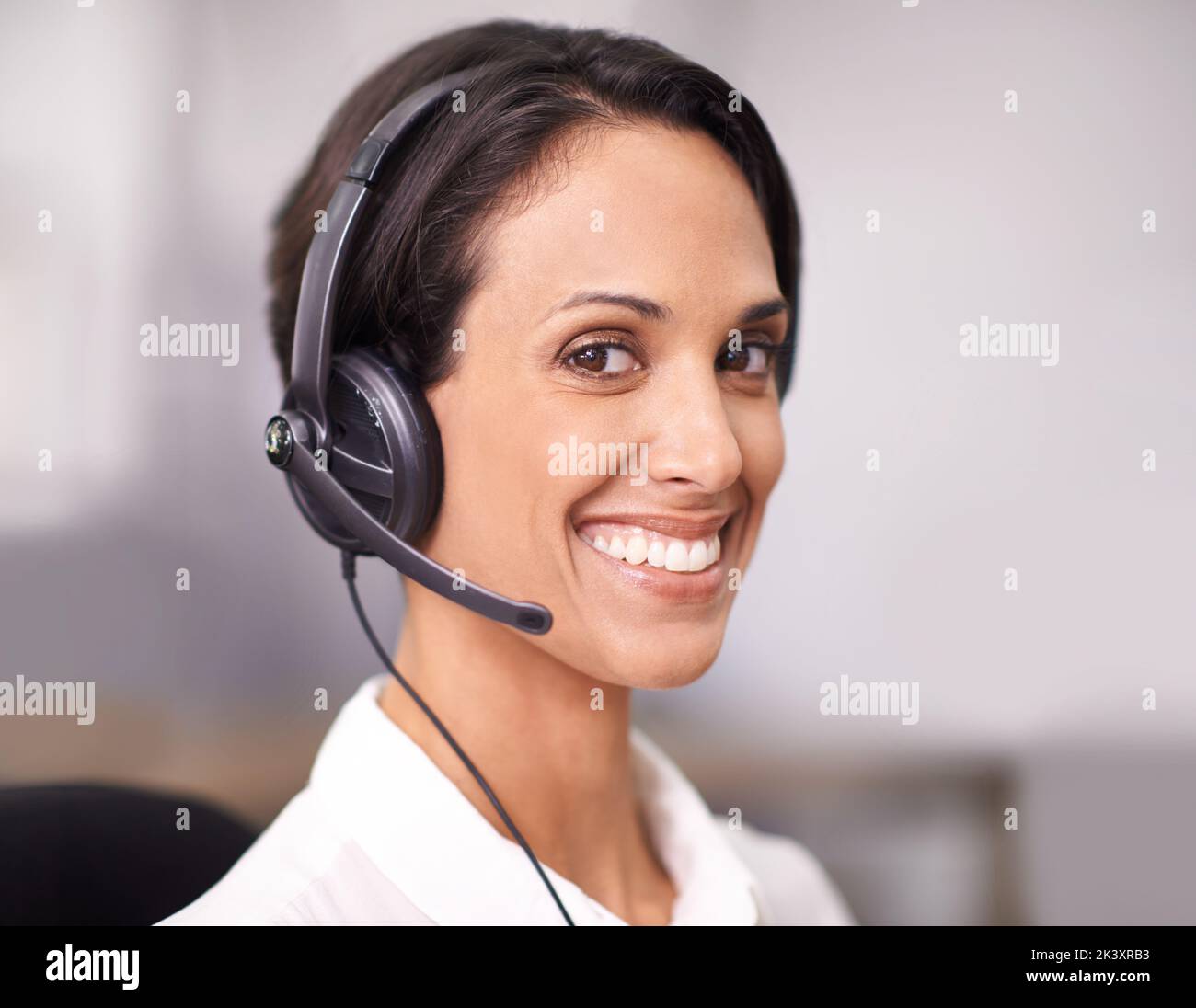 Service mit einem Lächeln. Porträt eines attraktiven jungen Büromitarbeiters, der ein Headset trägt. Stockfoto