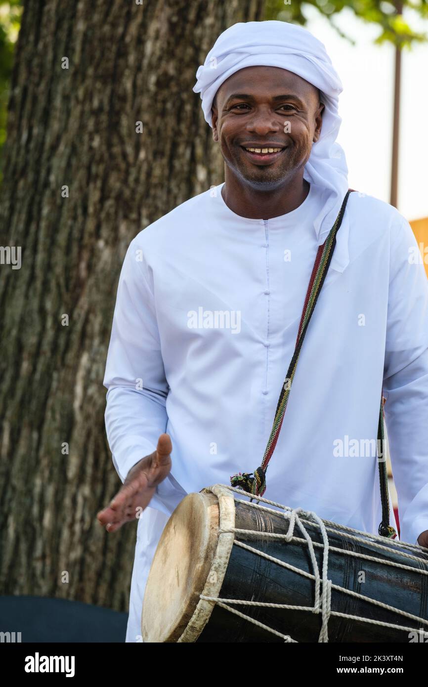 Vereinigte Arabische Emirate. Afro-arabischer Schlagzeuger in einem dishdasha, der auf einem Folklife Festival arabische musikalische Rhythmen vorführt. Stockfoto