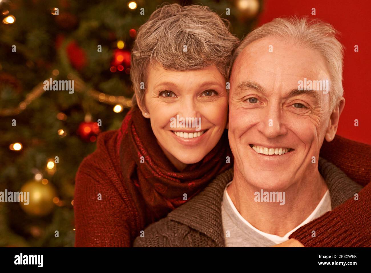 Eine Zeit, um die Angehörigen zu schätzen. Ein zugeschnittenes Porträt eines glücklichen älteren Paares vor einem Weihnachtsbaum. Stockfoto