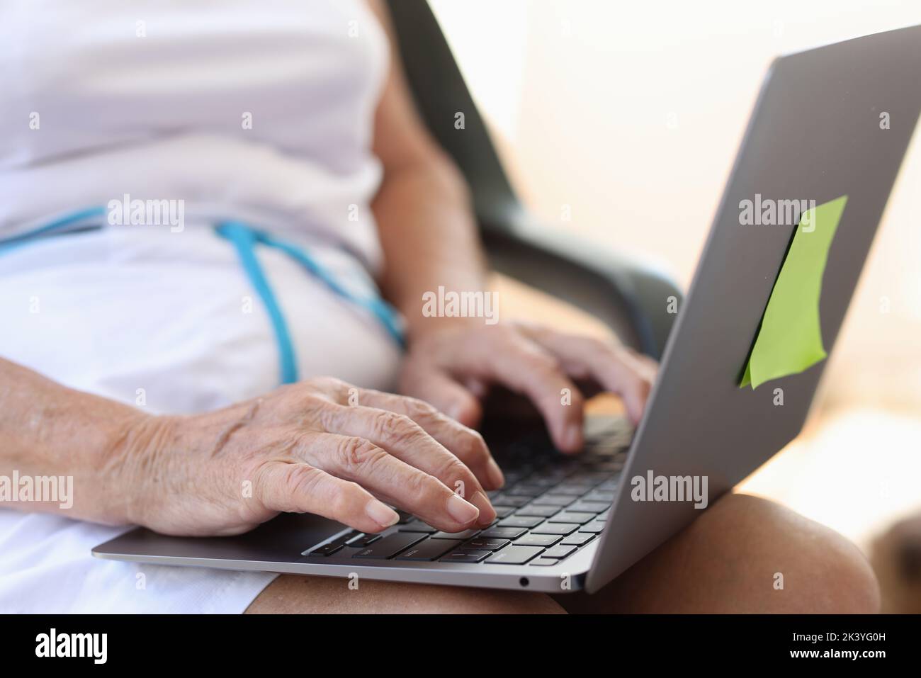Hände einer älteren Frau, die in Nahaufnahme auf der Laptop-Tastatur tippt Stockfoto
