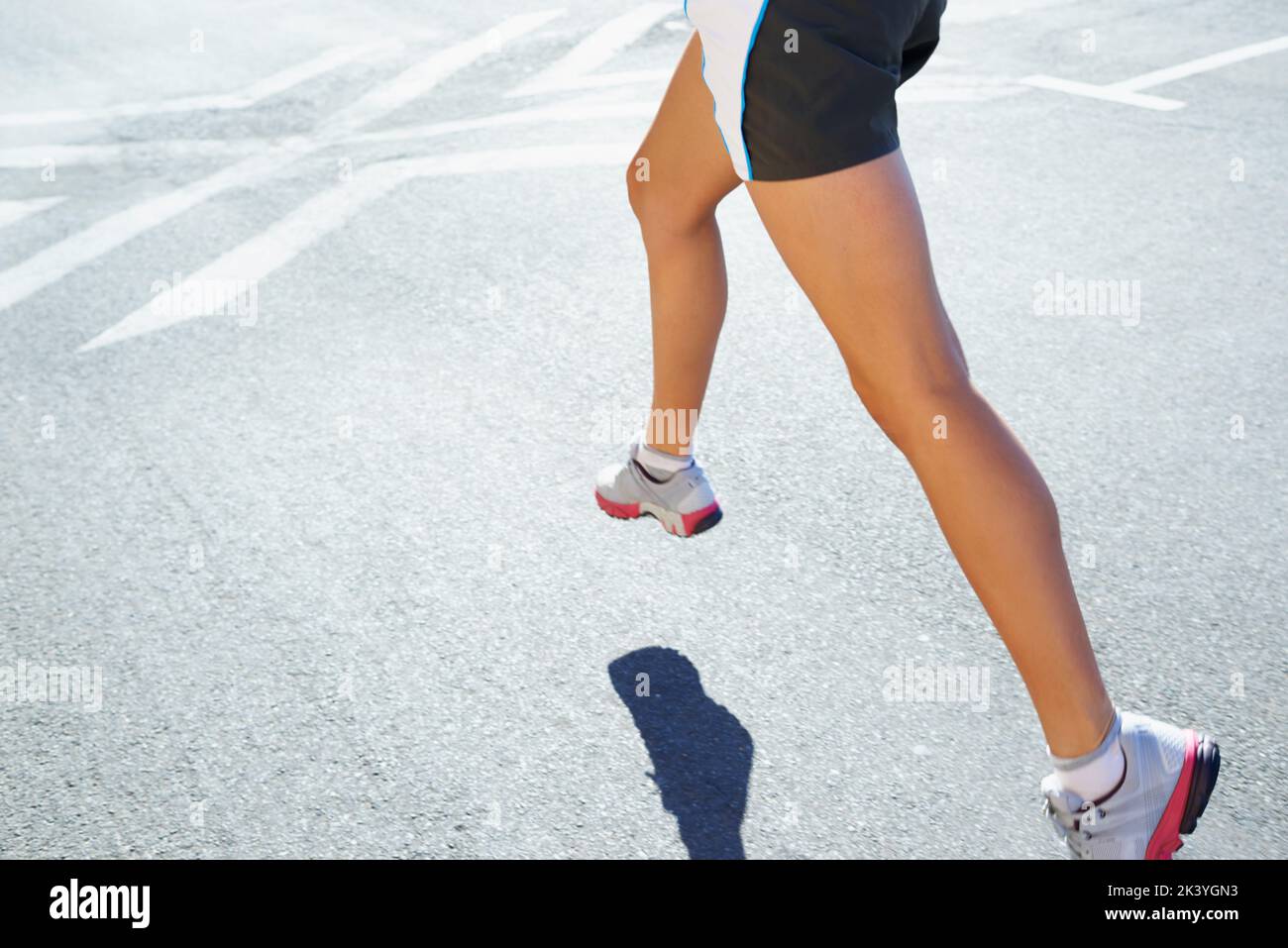 Immer fit ein Schritt nach dem anderen. Eine athletische junge Frau, die draußen läuft. Stockfoto