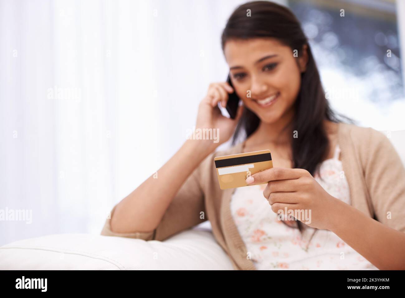 Vertrauen auf sicheres Online-Shopping. Eine junge Frau, die ihre Kreditkartendaten über das Telefon gab. Stockfoto