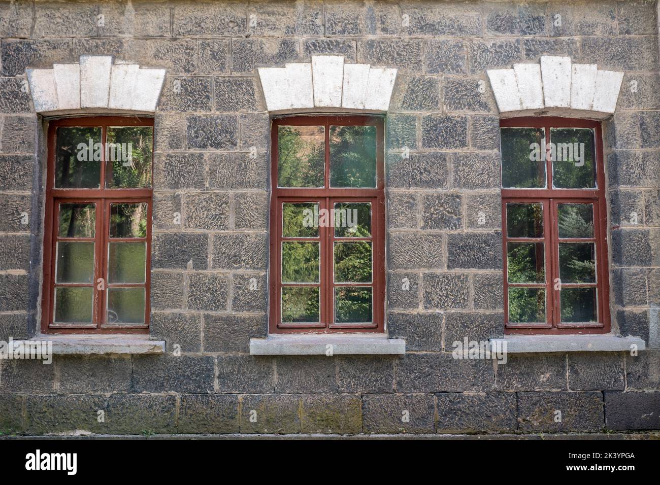 Ein altes klassisches Steinhaus mit Fenstern. Kalkige Steinwände und Fensterstrukturen. Hochwertige Fotos Stockfoto Ein altes klassisches Steinhaus mit Fenstern. Kalkige Steinwände und Fensterstrukturen. Hochwertige Fotos Stockfoto