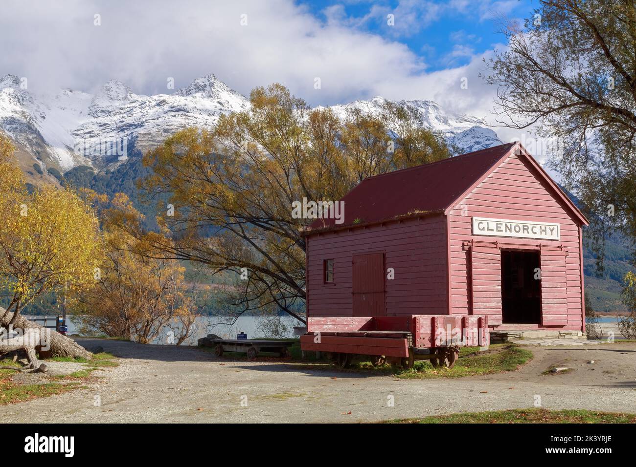 Das alte Dampfschiff-Depot in Glenorchy, Neuseeland, auch bekannt als "Red Shed", mit Herbstbäumen und den Humboldt-Bergen im Hintergrund Stockfoto