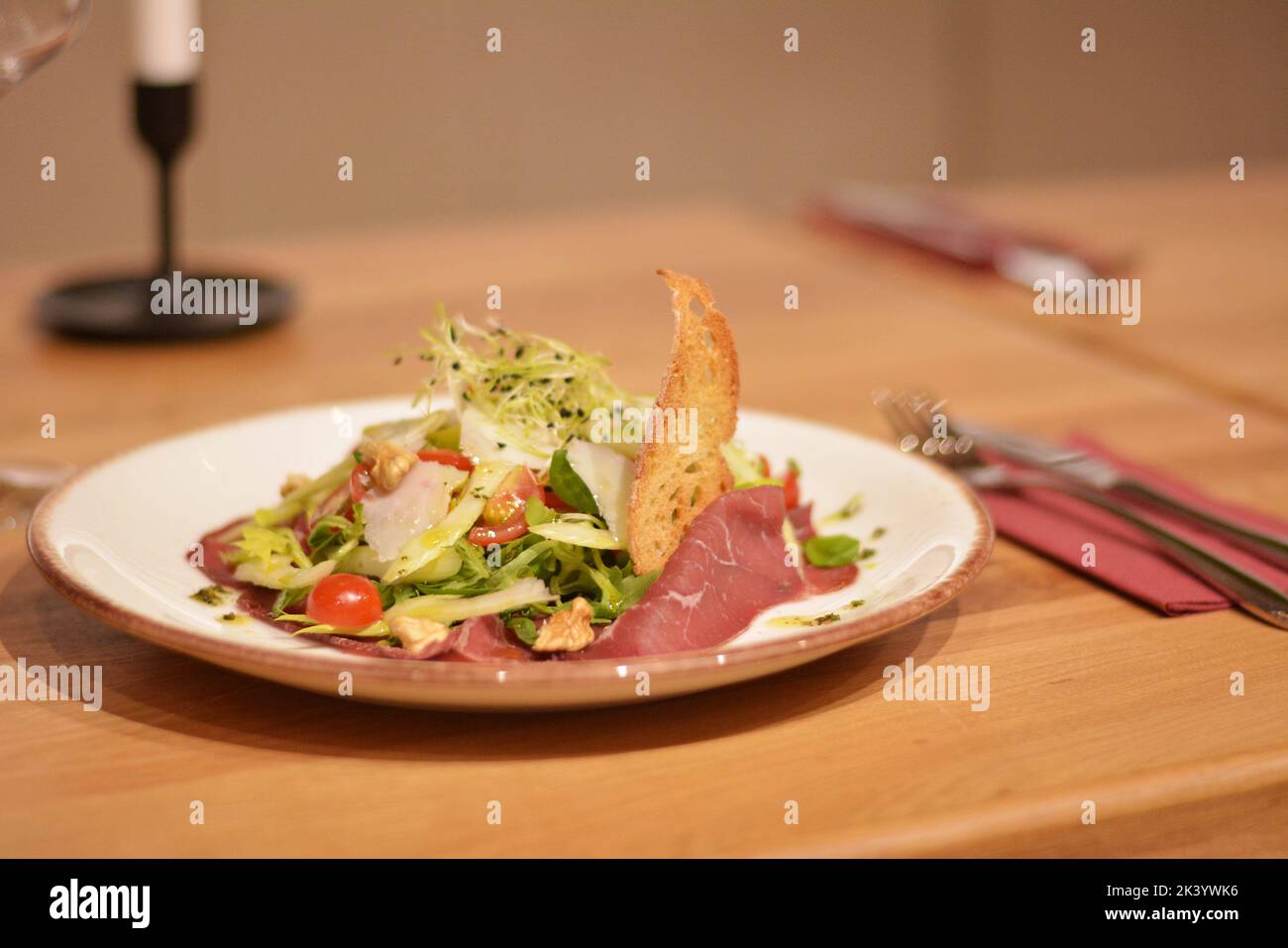 Spanischer Schinken mit grünem Salat, Tomaten und Weizenkörnern. Stockfoto