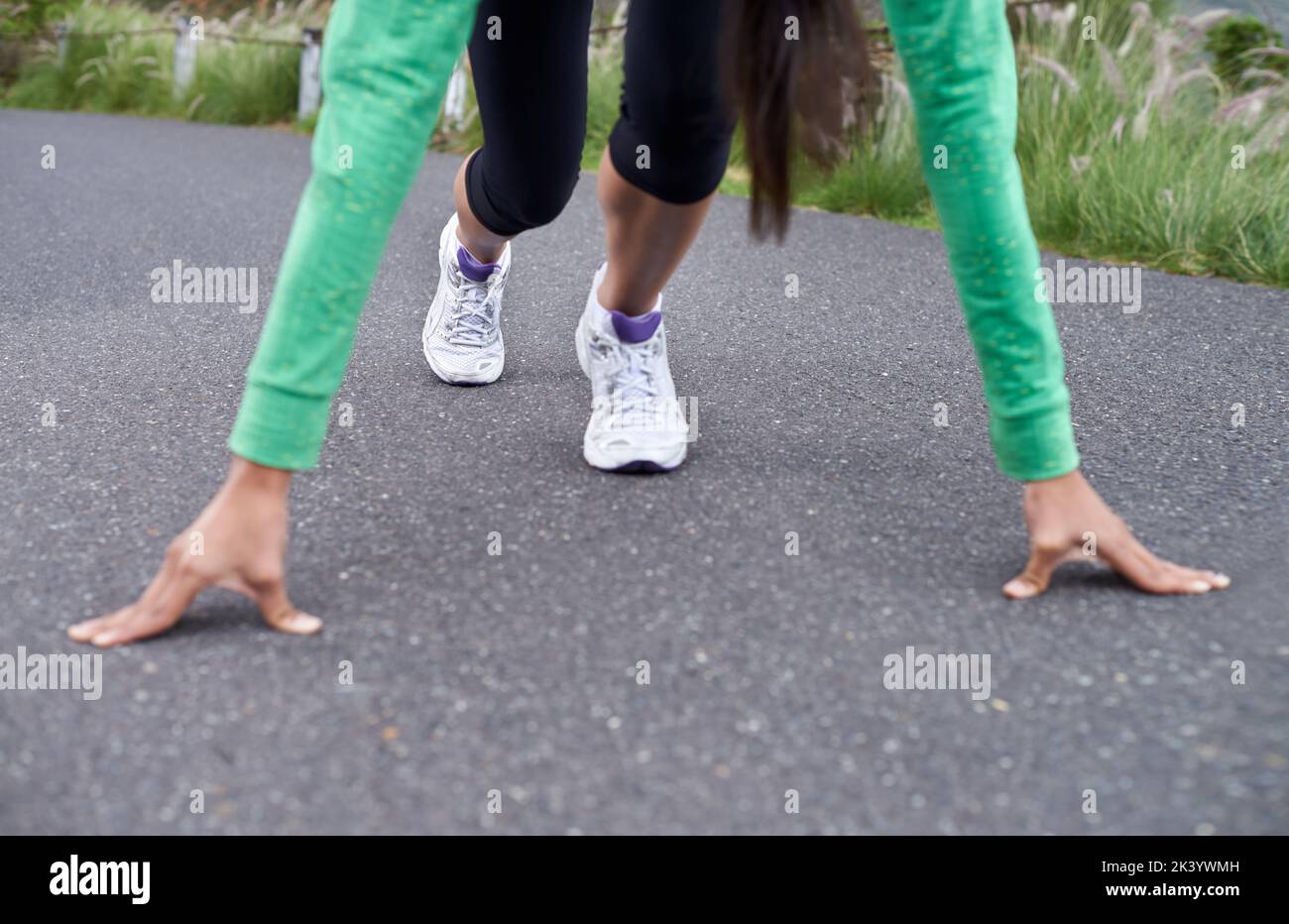 Intensive Vorbereitung. Eine junge Frau, die auf der Straße hockend, um zu laufen. Stockfoto