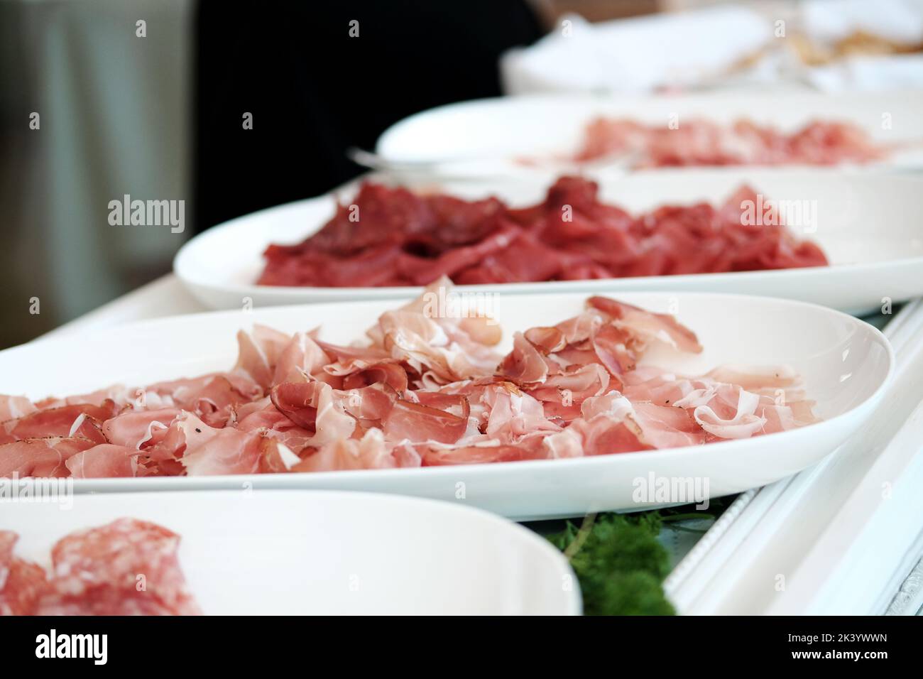 Weiße Teller mit verschiedenen Schinkenarten. Prosciutto. Stockfoto