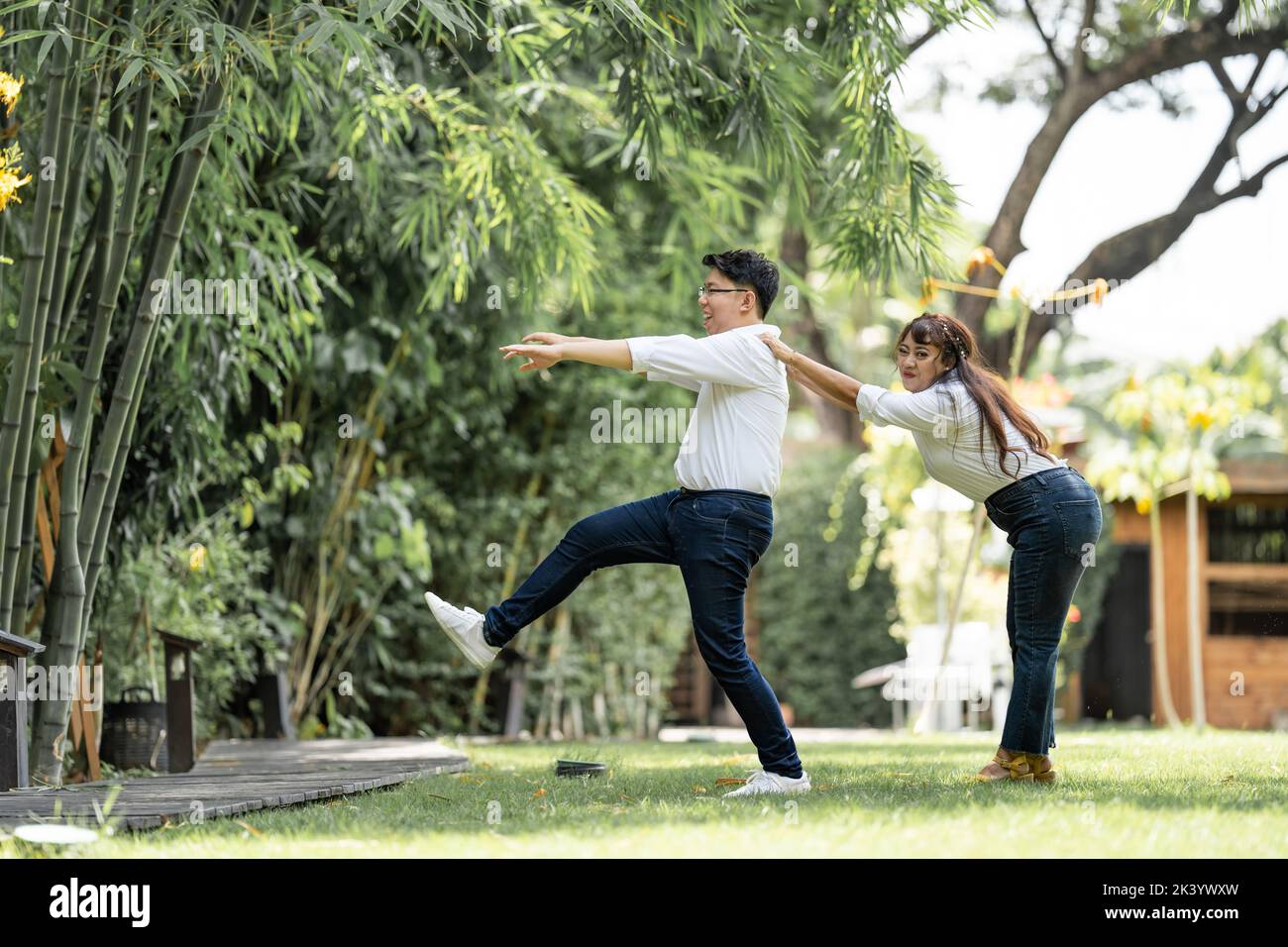 Asiatische Frau greift und fängt Mann Schulter und versteifung der Mann, um mit ihr zu leben. Stockfoto