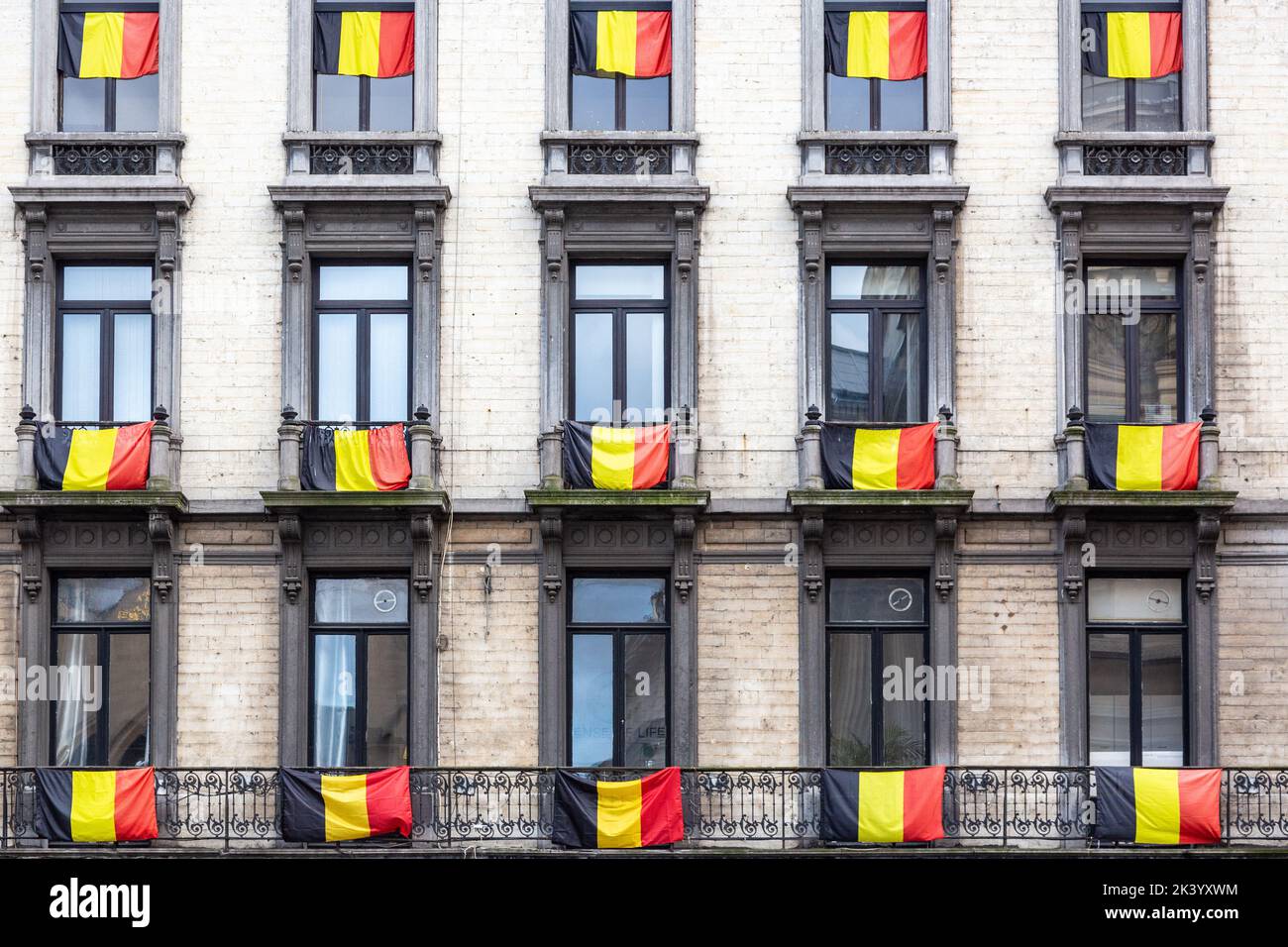 Belgische Flaggen hängen an allen Fenstern eines Gebäudes. Brüssel. Stockfoto