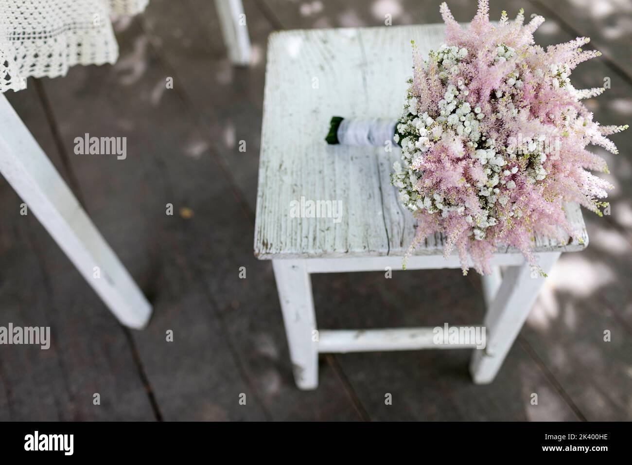 Ein wunderschöner Braut-Hochzeitsstrauß aus verschiedenen bunten Blumen, der vor einem weichen natürlichen Hintergrund im Freien platziert ist und elegante Details zur Schau stellt. Stockfoto