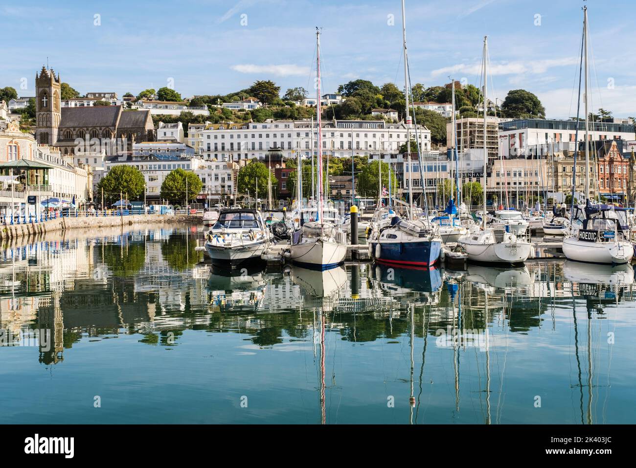 Die Boote, die im Binnendock des Hafens festgemacht wurden, spiegeln sich im ruhigen Wasser wider. Torquay, Devon, England, Großbritannien Stockfoto