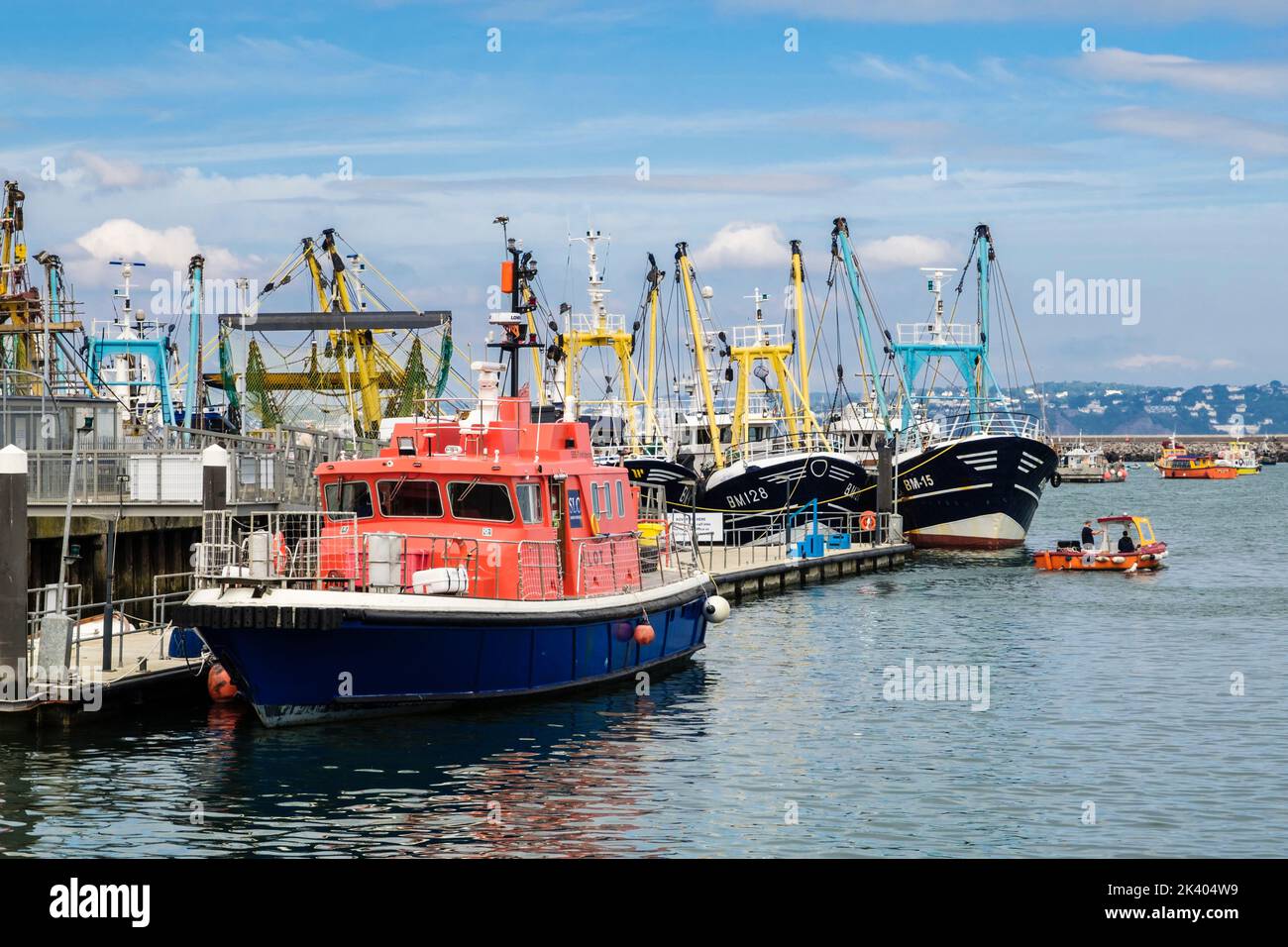 Lotsenboot und kommerzielle Fischereiflotte im Hafen im Außenhafen. Brixham, Devon, England, Großbritannien Stockfoto