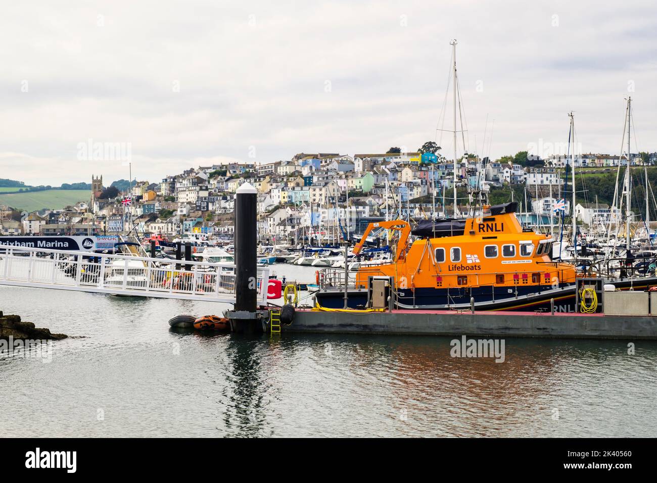 RNLI Rettungsboot an einem Steg im Hafen mit der Stadt dahinter. Brixham, Devon, England, Großbritannien Stockfoto