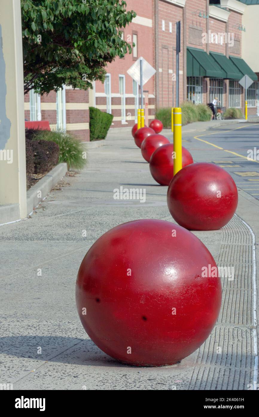 Die unverkennbaren riesigen roten Betonkugeln außerhalb eines Target-Ladens schützen vor Eindringlingen in Autos. In Mt. Kisco, Westchester, New York. Stockfoto