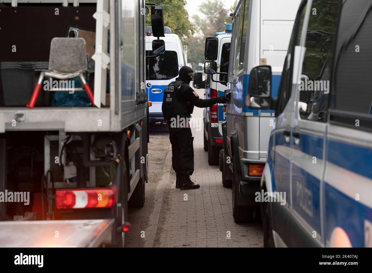 Berlin, Deutschland. 29. September 2022. Ein Polizeibeamter steht zwischen Einsatzfahrzeugen im Clubhaus der Rockergruppe 'Hells Angels MC Berlin Central' in Berlin. Aufgrund krimineller Aktivitäten wurde die Gruppe vom Berliner Innensenator verboten und aufgelöst. Quelle: Paul Zinken/dpa/Alamy Live News Stockfoto