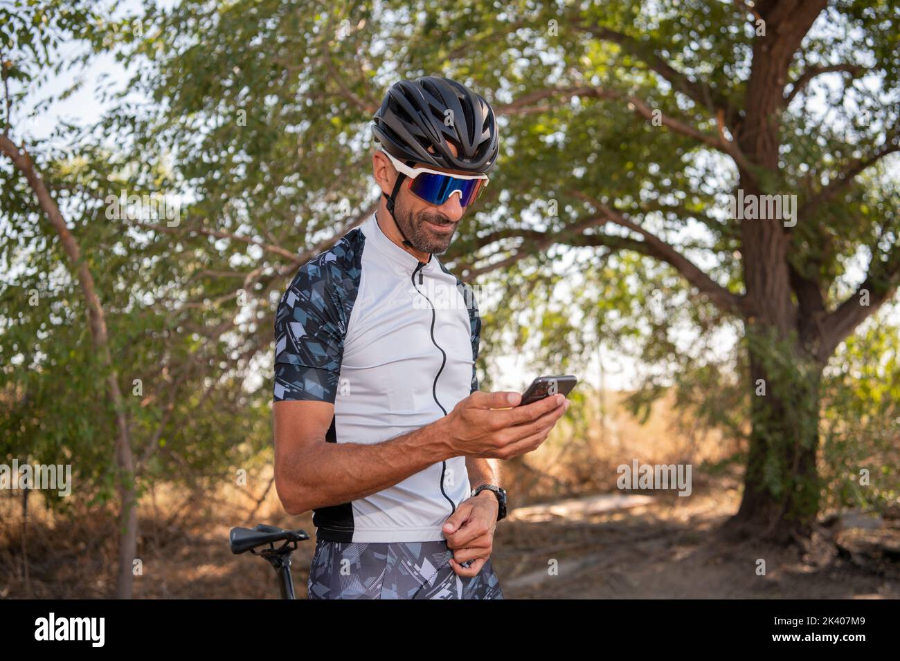 Der Cyclist überprüft die Ergebnisse auf seinem Smartphone After Riding . Sport Fitness Motivation Und Inspiration. Extremsport, Triathlon. Stockfoto