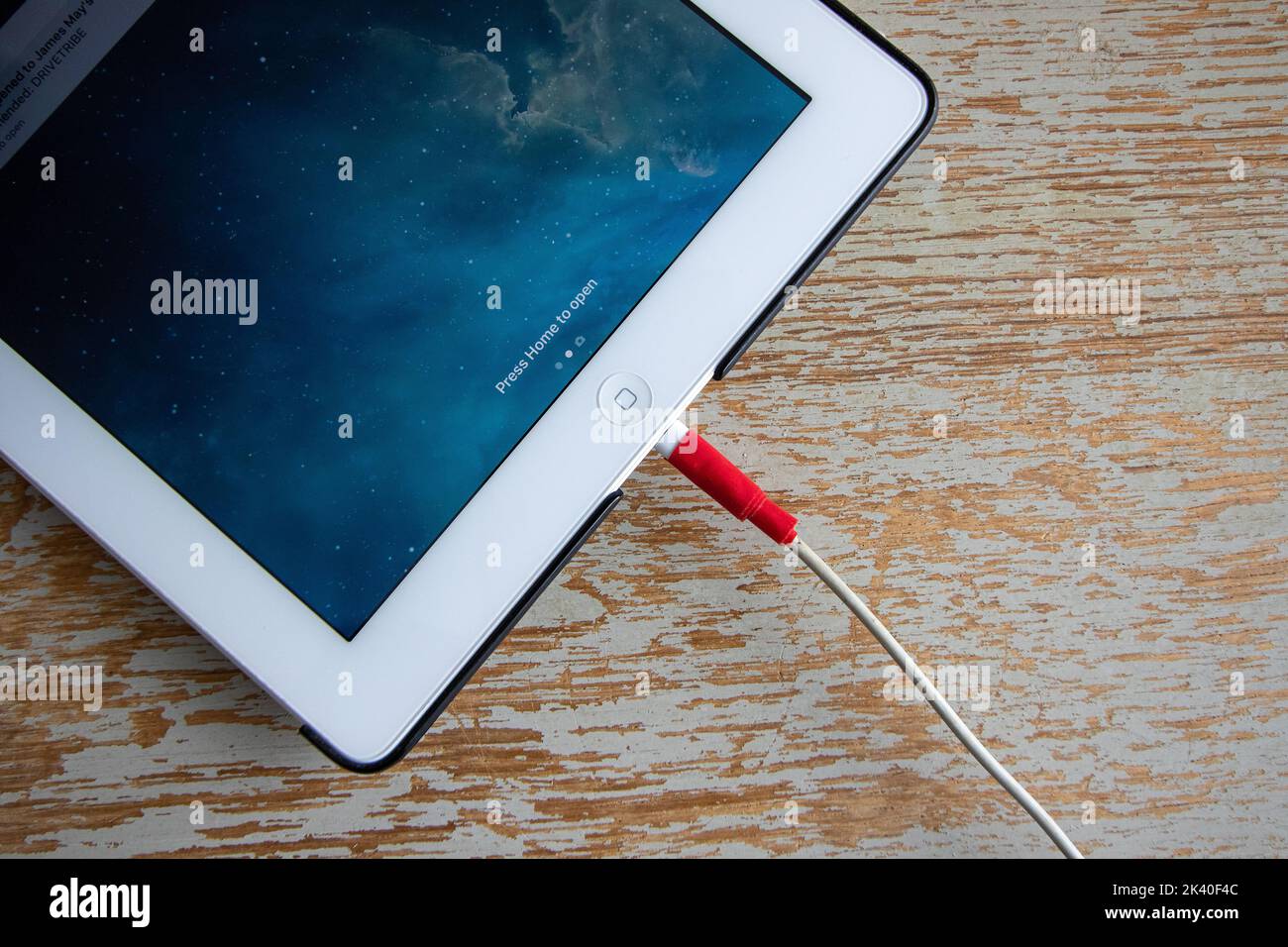 Ein Apple-Anschluss, der unzuverlässig mit klebrigem rotem Isolierband repariert wurde Stockfoto