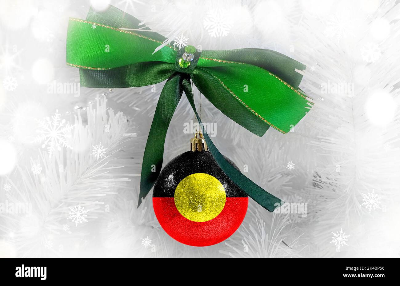 Neujahrsglass mit der Flagge der australischen Aborigines vor einem farbenfrohen Weihnachtshintergrund Stockfoto
