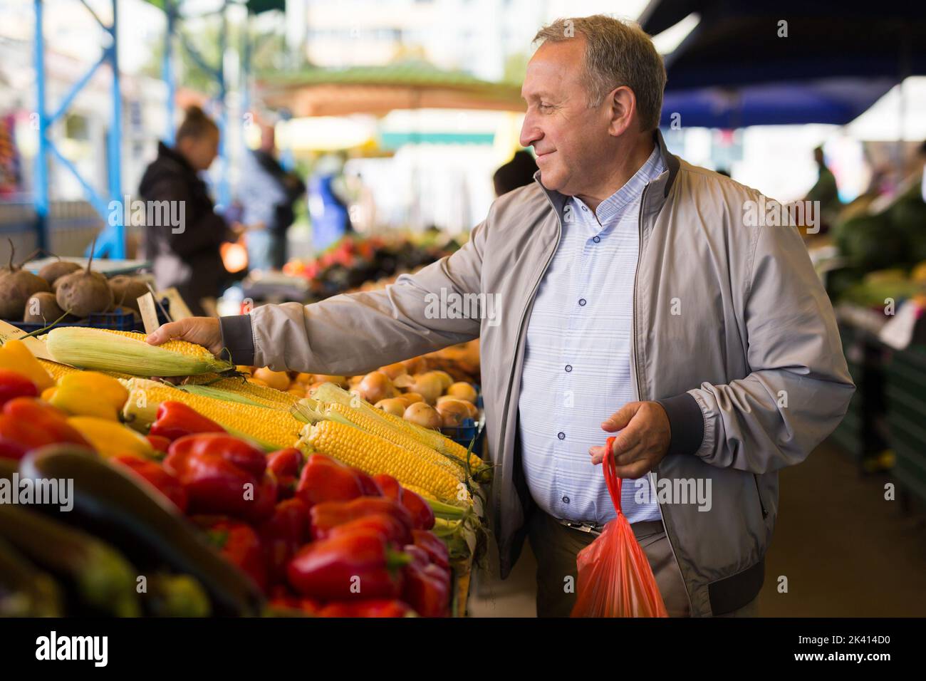 Mann mittleren Alters, der Gemüse kauft Stockfoto