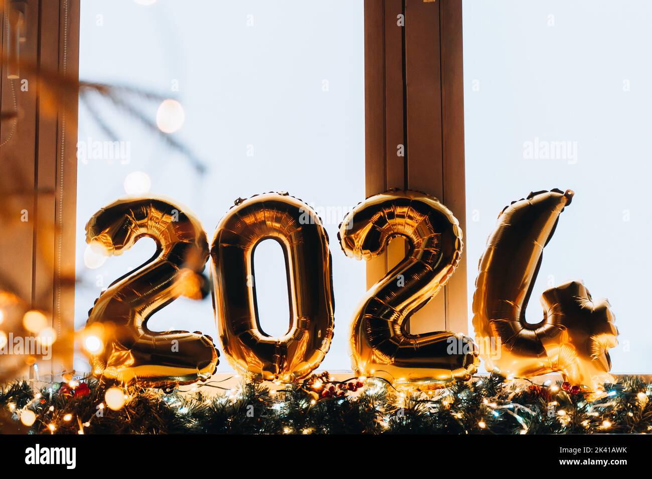 2024 goldene Folienballons auf blauer Fensterbank. Feiern Sie Ihren